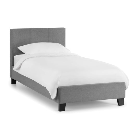Gray upholstered bed with white bedding on a white background
