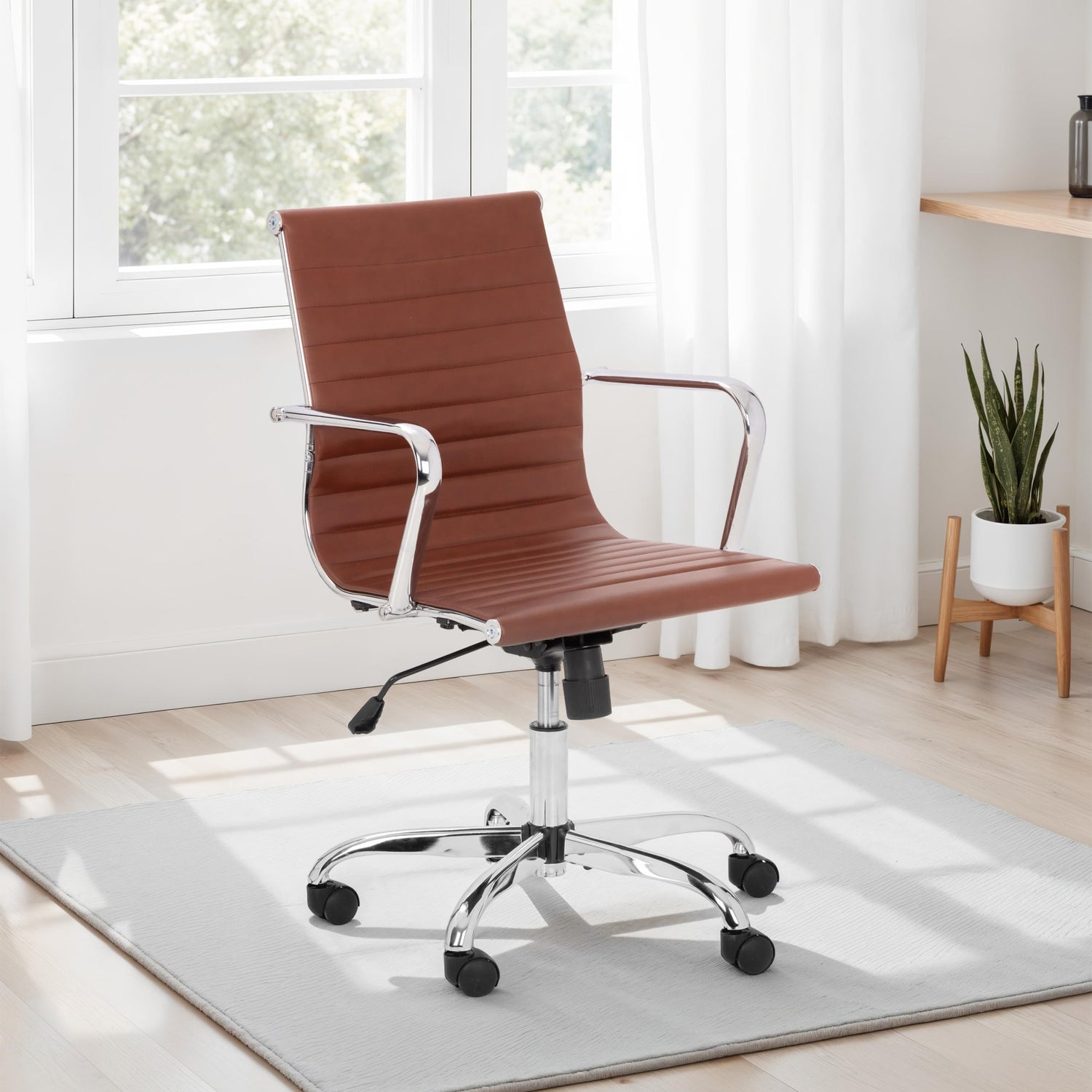 Brown office chair in a bright room with a plant and desk.