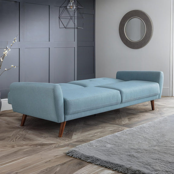 Light blue sofa in a modern living room with gray walls and a rug.