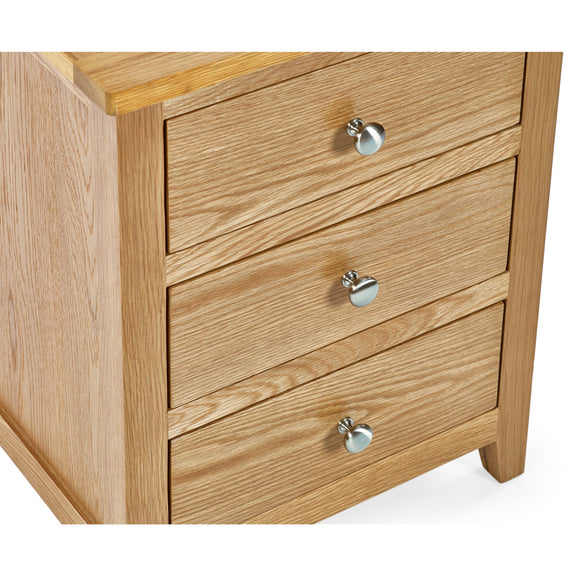 Wooden dresser with three drawers and silver knobs on a white background