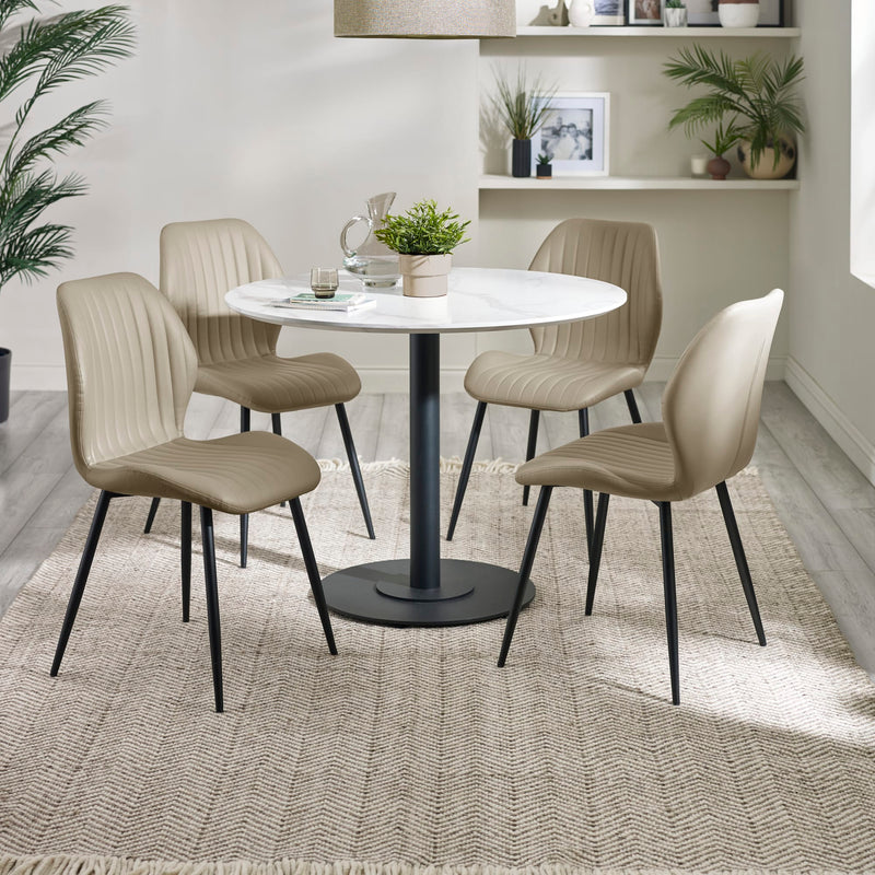 Dining room with a round table and four beige chairs on a textured rug.