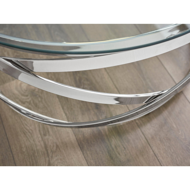 Glass coffee table with chrome metal base on a wooden floor