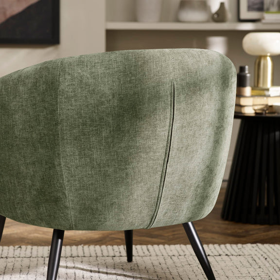 Green upholstered chair in a room with a blurred background