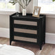 Black nightstand with wicker drawers in a bedroom setting