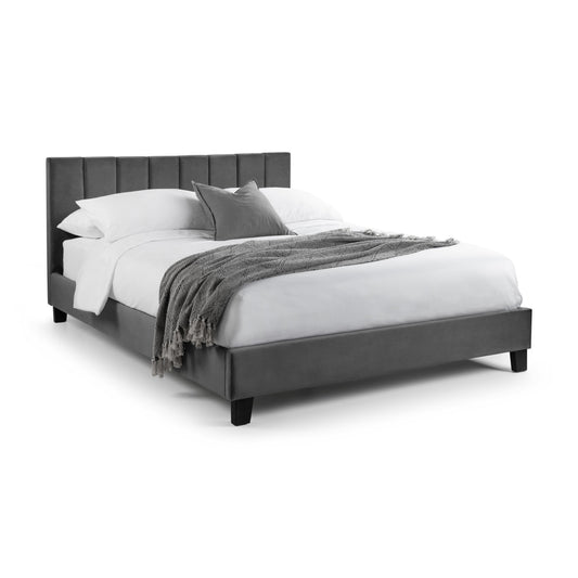 Gray upholstered bed with white bedding and gray blanket on a white background
