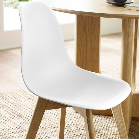 White chair with wooden legs in a room with a wooden table and light-colored floor.