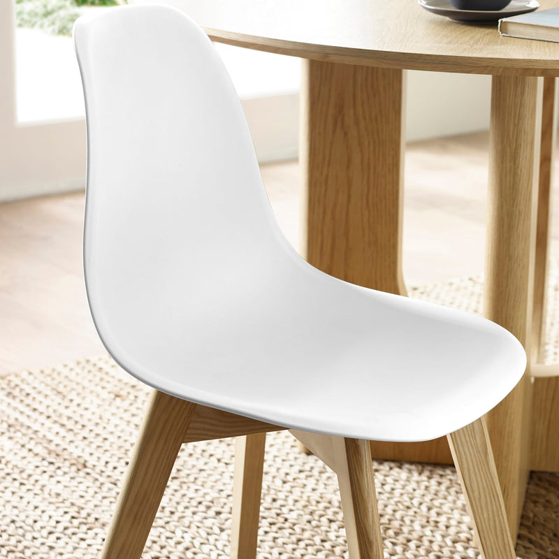 White chair with wooden legs in a room with a wooden table and light-colored floor.