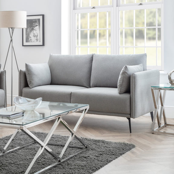 Modern living room with a gray sofa, glass coffee table, and decorative elements.