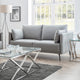 Modern living room with a gray sofa, glass coffee table, and decorative elements.