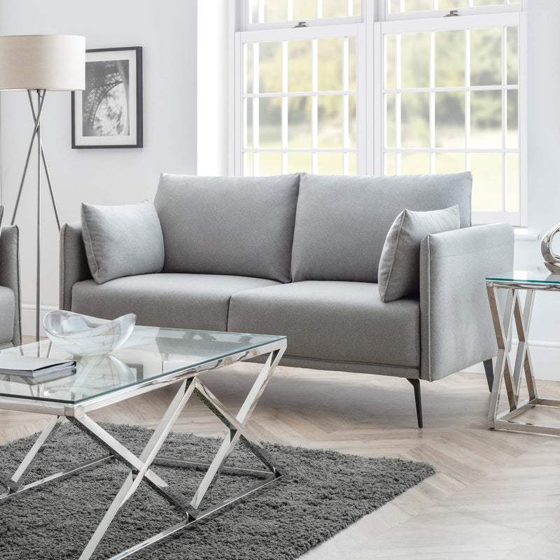 Modern living room with a gray sofa, glass coffee table, and decorative elements.