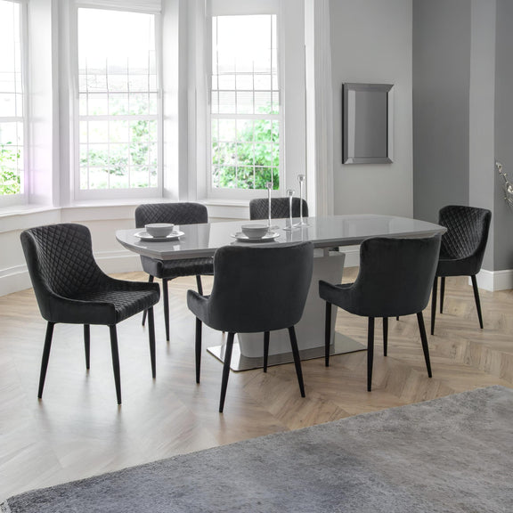 Dining room with a round glass table and black chairs in a modern interior.