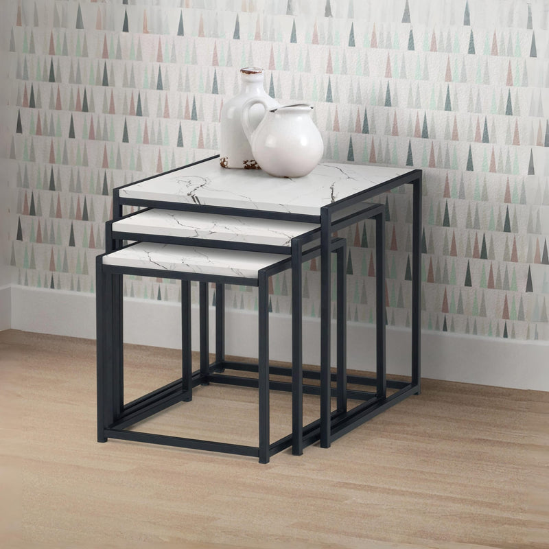 Set of three nesting tables with marble-like tops against a patterned wall.