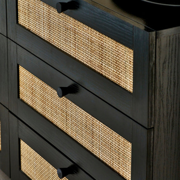 Black dresser with woven drawer fronts on a dark background