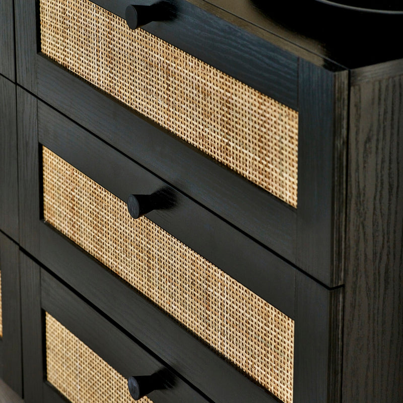 Black dresser with woven drawer fronts on a dark background