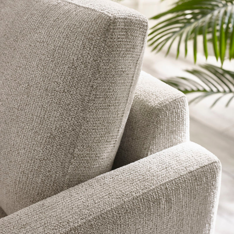 Close-up of a textured gray armchair with a blurred background