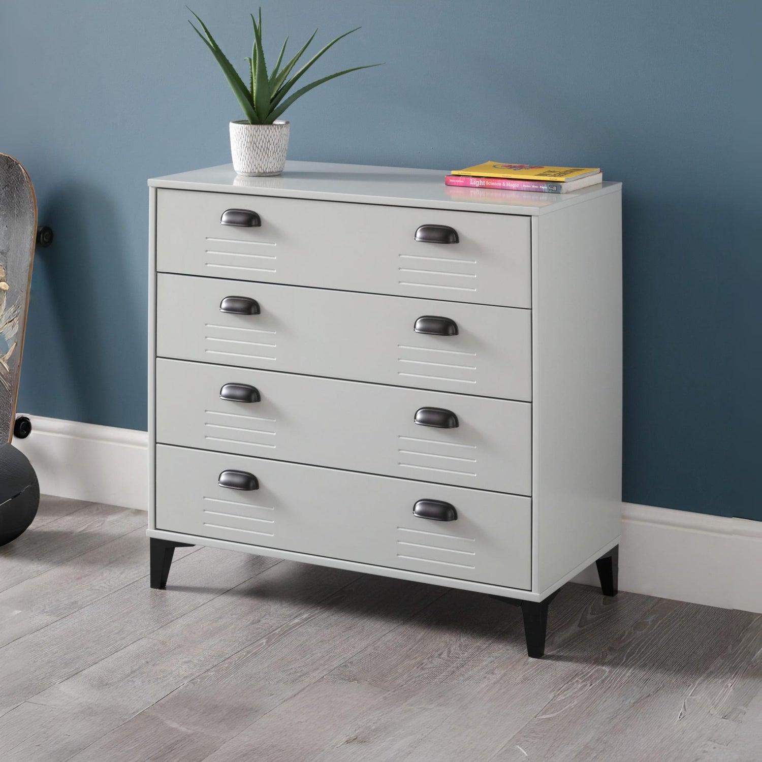 White dresser with black handles against a blue wall