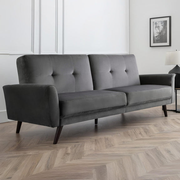 Gray sofa in a room with wooden flooring and a white wall.
