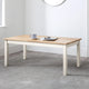 Wooden coffee table with a white base in a room with a light gray carpet.
