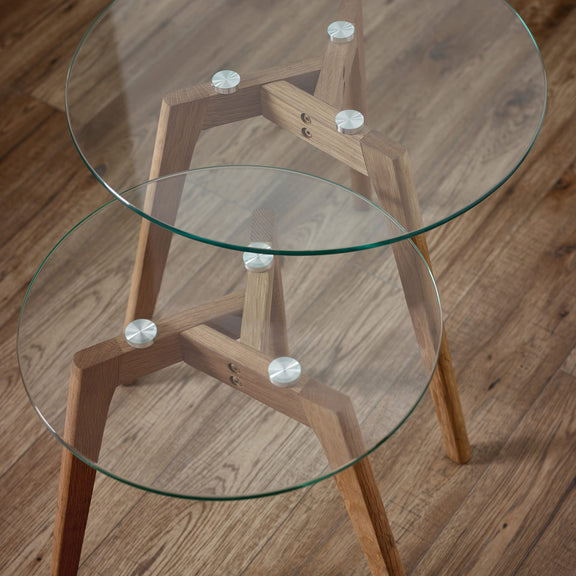 Glass top table with wooden legs on a wooden floor