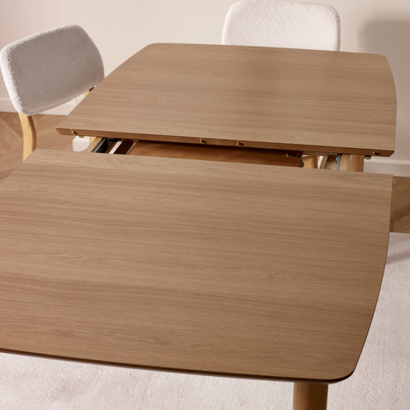 Wooden dining table with a drawer extension in a neutral setting