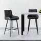 Two black bar stools in front of a small round table on a light gray floor.