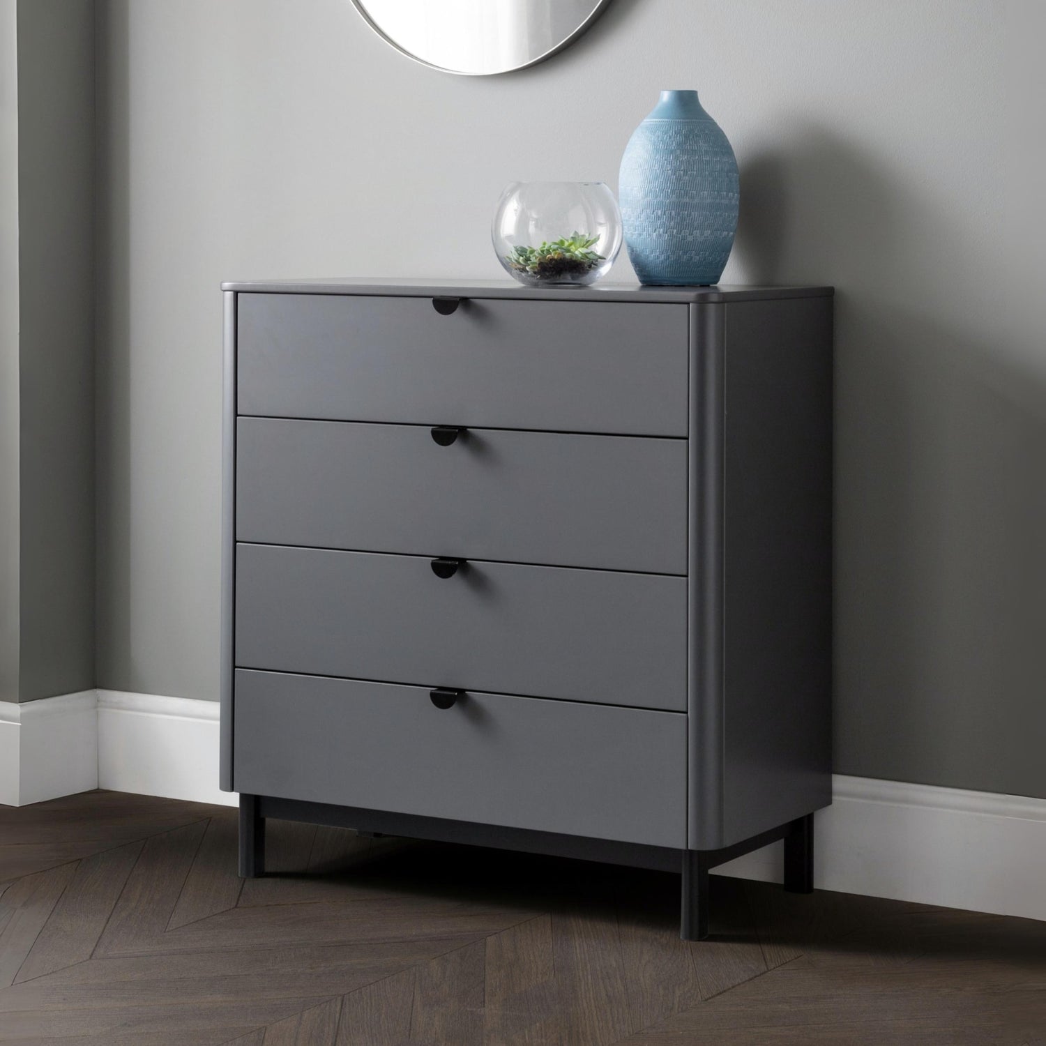 Gray dresser with three drawers against a gray wall.