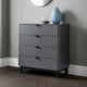 Gray dresser with three drawers against a gray wall.