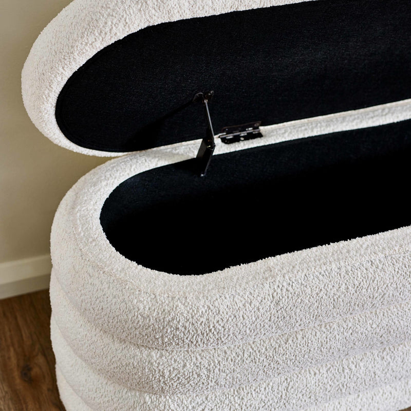 White storage ottoman with a black interior and zipper, on a wooden floor.