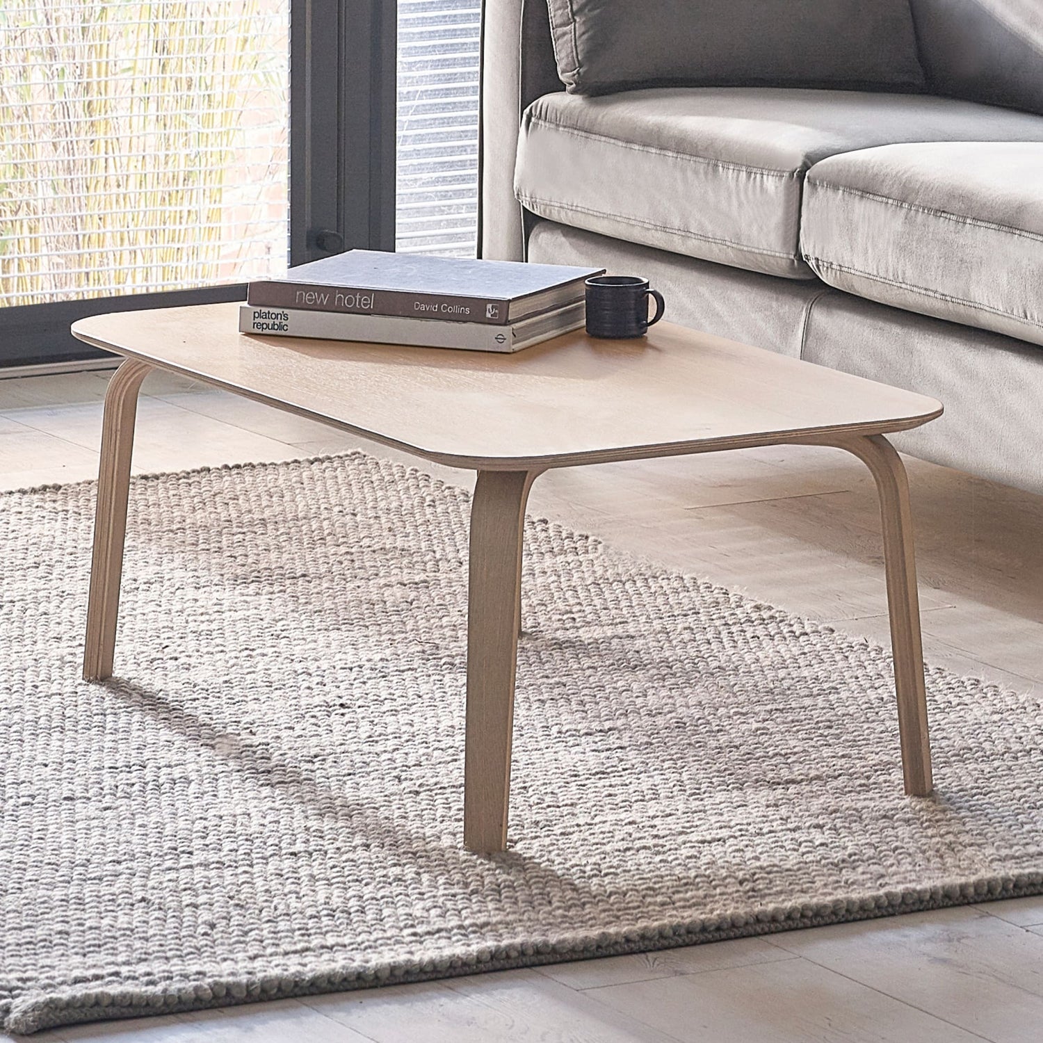 Coffee table with books and a mug in a living room setting