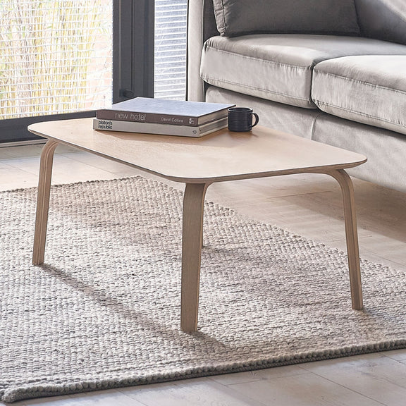 Coffee table with books and a mug in a living room setting