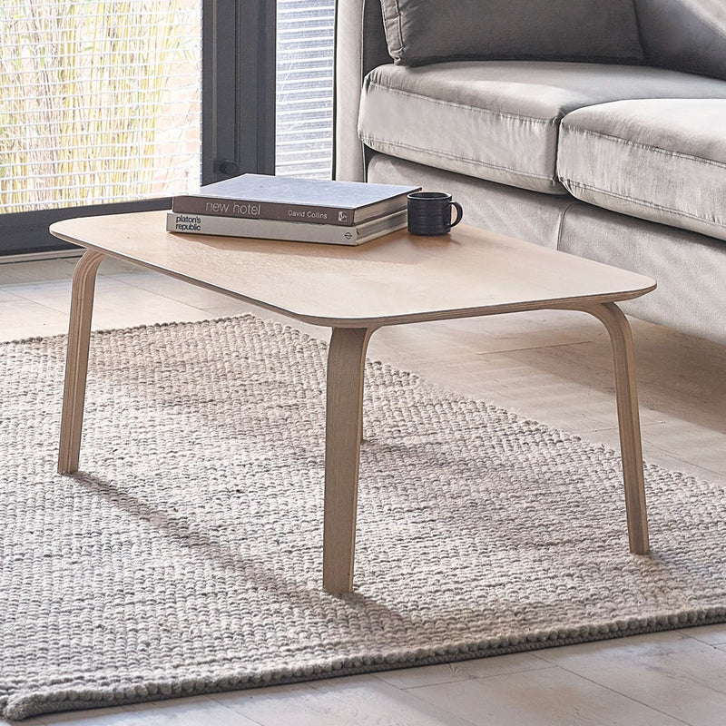 Coffee table with books and a mug in a living room setting
