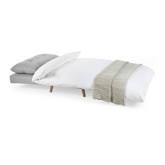 Bed with gray headboard, white bedding, and green blanket on a white background
