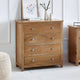 Wooden dresser with four drawers in a room setting.
