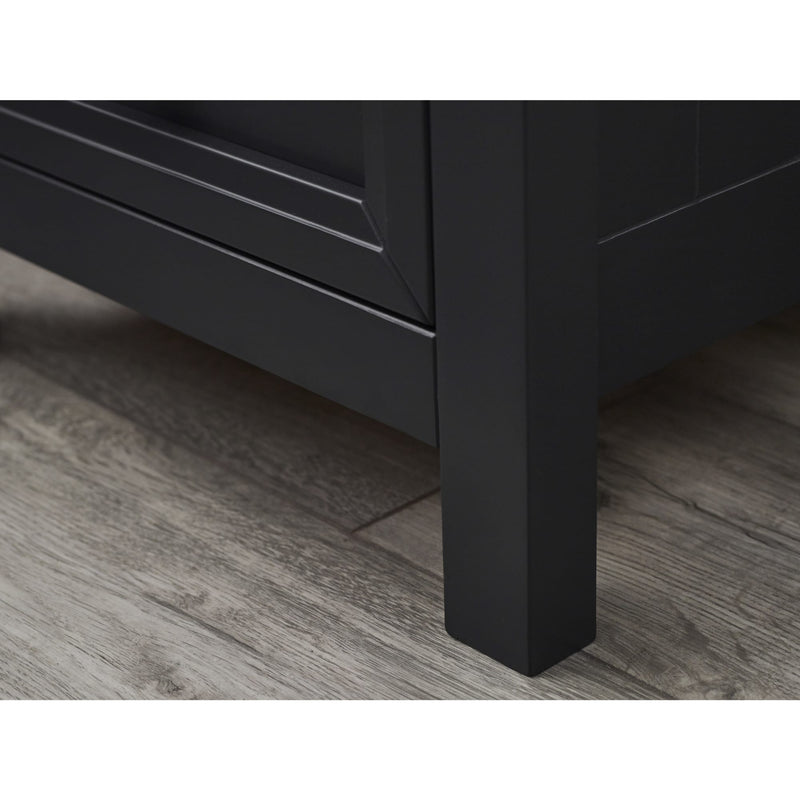 Close-up of a black wooden leg on a floor.