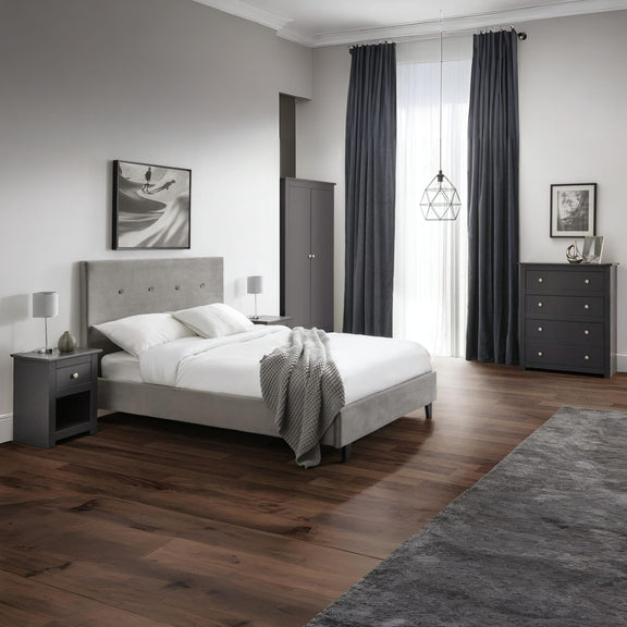 Modern bedroom with gray upholstered bed, nightstands, and curtains.