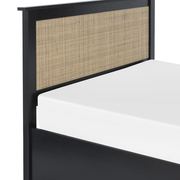 Bed with black frame and woven headboard on a white background