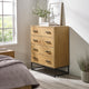 Wooden dresser with four drawers in a bedroom setting