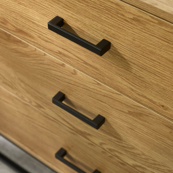 Close-up of wooden drawers with black handles