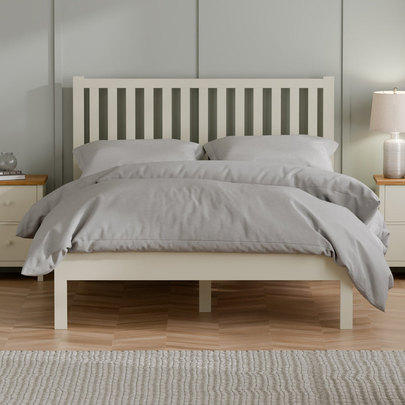 Bedroom with a wooden bed frame, gray bedding, and nightstands.