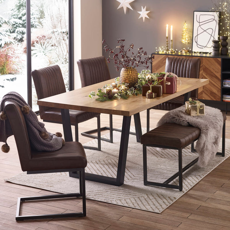Dining room with a wooden table and chairs, decorated for Christmas.