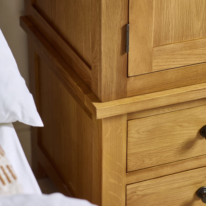 Wooden wardrobe with two doors and two drawers in a bedroom setting.