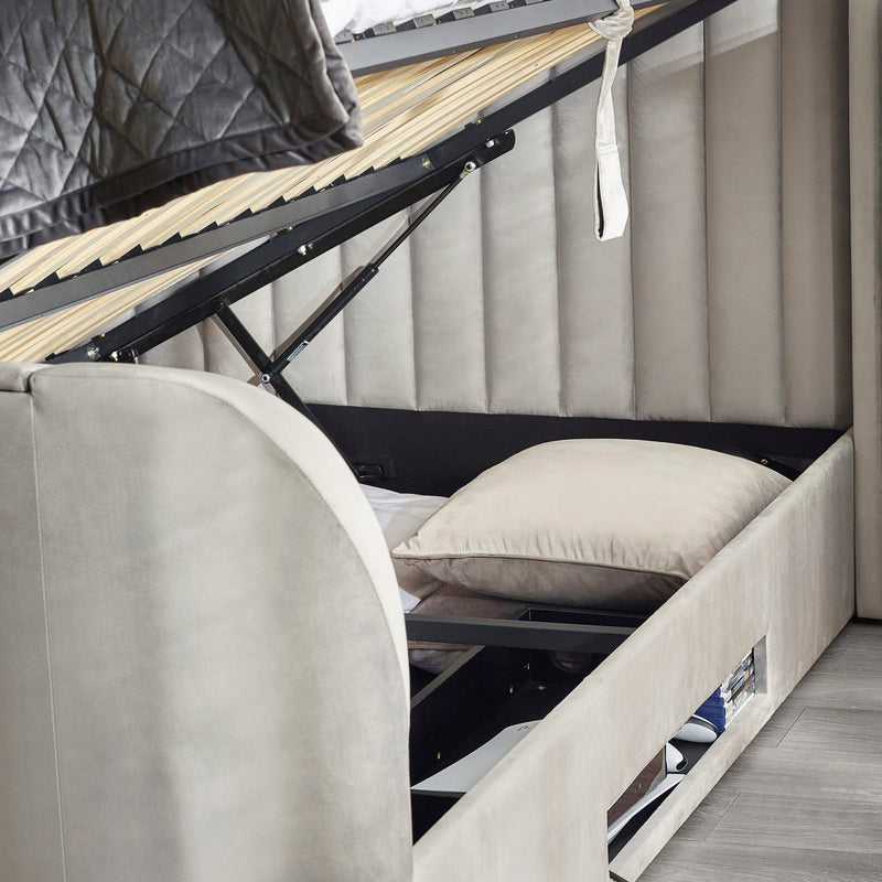 Gray upholstered bed with a wooden slat support system in a room setting.