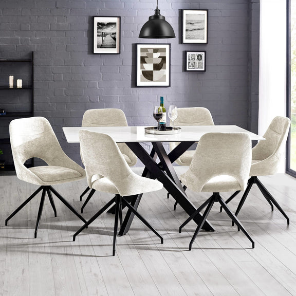 Dining room with a black and white table and chairs against a gray brick wall.