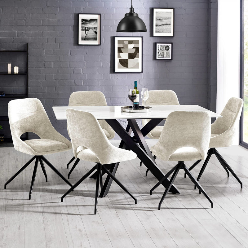 Dining room with a black and white table and chairs against a gray brick wall.