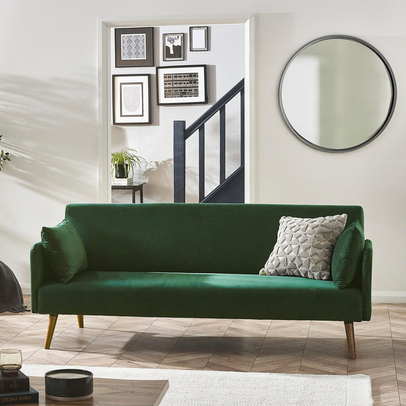 Green sofa with decorative pillows in a living room setting.