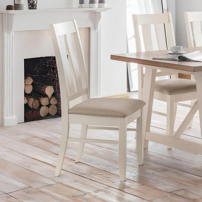 Dining room with wooden table and chairs in front of a fireplace.