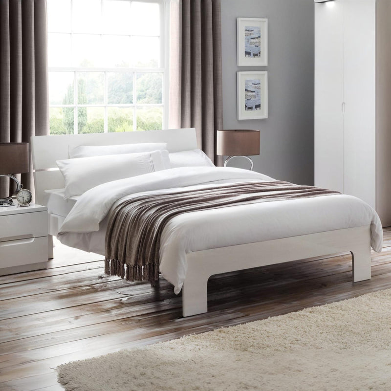 Modern bedroom with a white bed, nightstands, and decor.