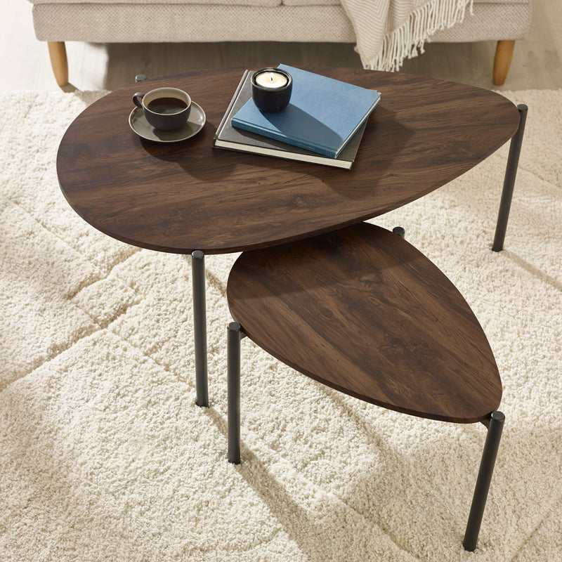 Wooden coffee table with a book, mug, and candle on a light carpet