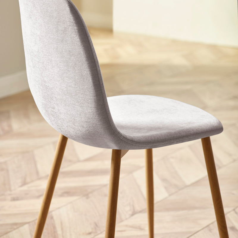 Gray upholstered chair with wooden legs on a light wood floor.