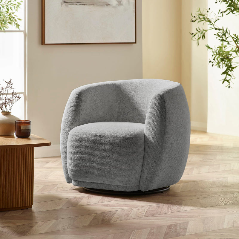 Gray armchair in a modern living room with a wooden table and plants.